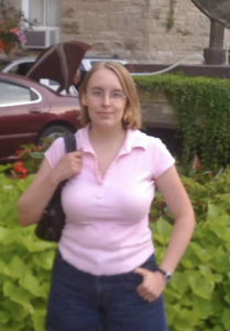 Woman standing near greenery.