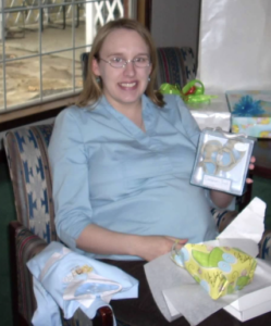 Pregnant woman holding baby gifts.