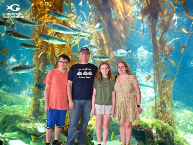 Family posed in front of a tropical fish tank