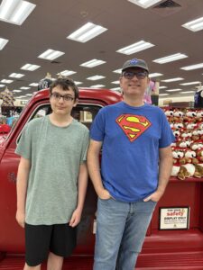 Two men in front of an antique truck