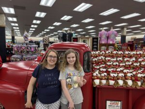 Two women in front of an antique truck