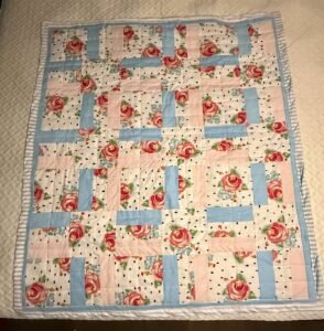 A blue, white, and pink floral quilt.
