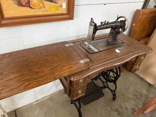 Vintage treadle sewing machine in cabinet.